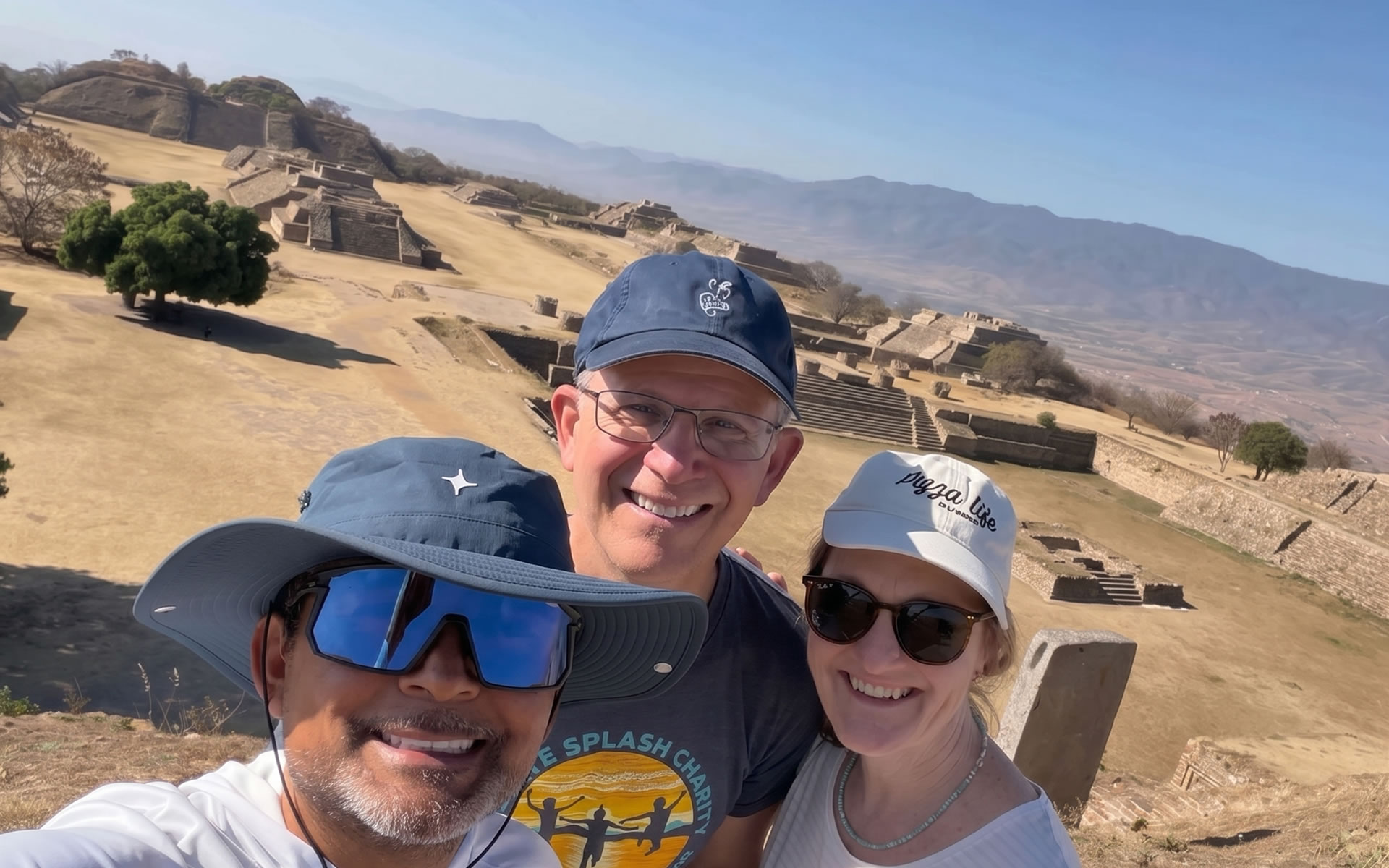 Wide view of the Main Plaza at Monte Albán with surrounding pyramids and the Oaxaca Valley in the background