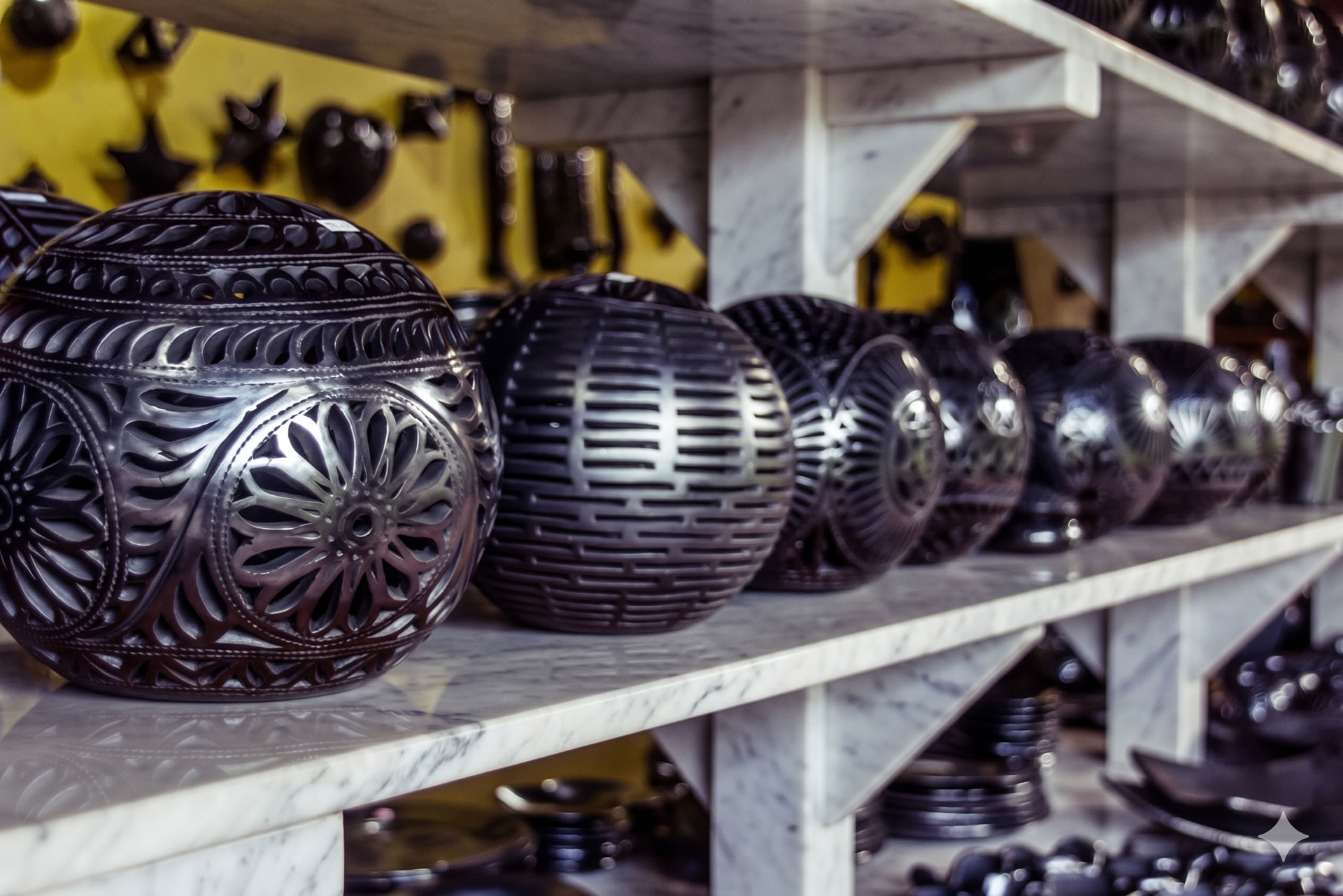 Artisan polishing a piece of shiny black pottery with a smooth quartz stone in a traditional workshop in San Bartolo Coyotepec, Oaxaca