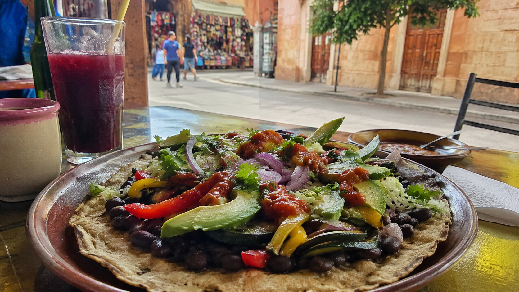 Colorful vegan tlayuda and fresh market produce in Oaxaca City, Mexico